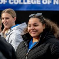 Alumni and staff smile and chat at Reunion Row